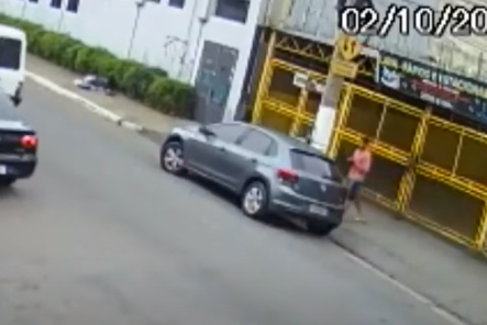 Imagem de câmera de segurança mostra carro parado na lateral de rua, com homem se aproximando de uma das portas traseiras