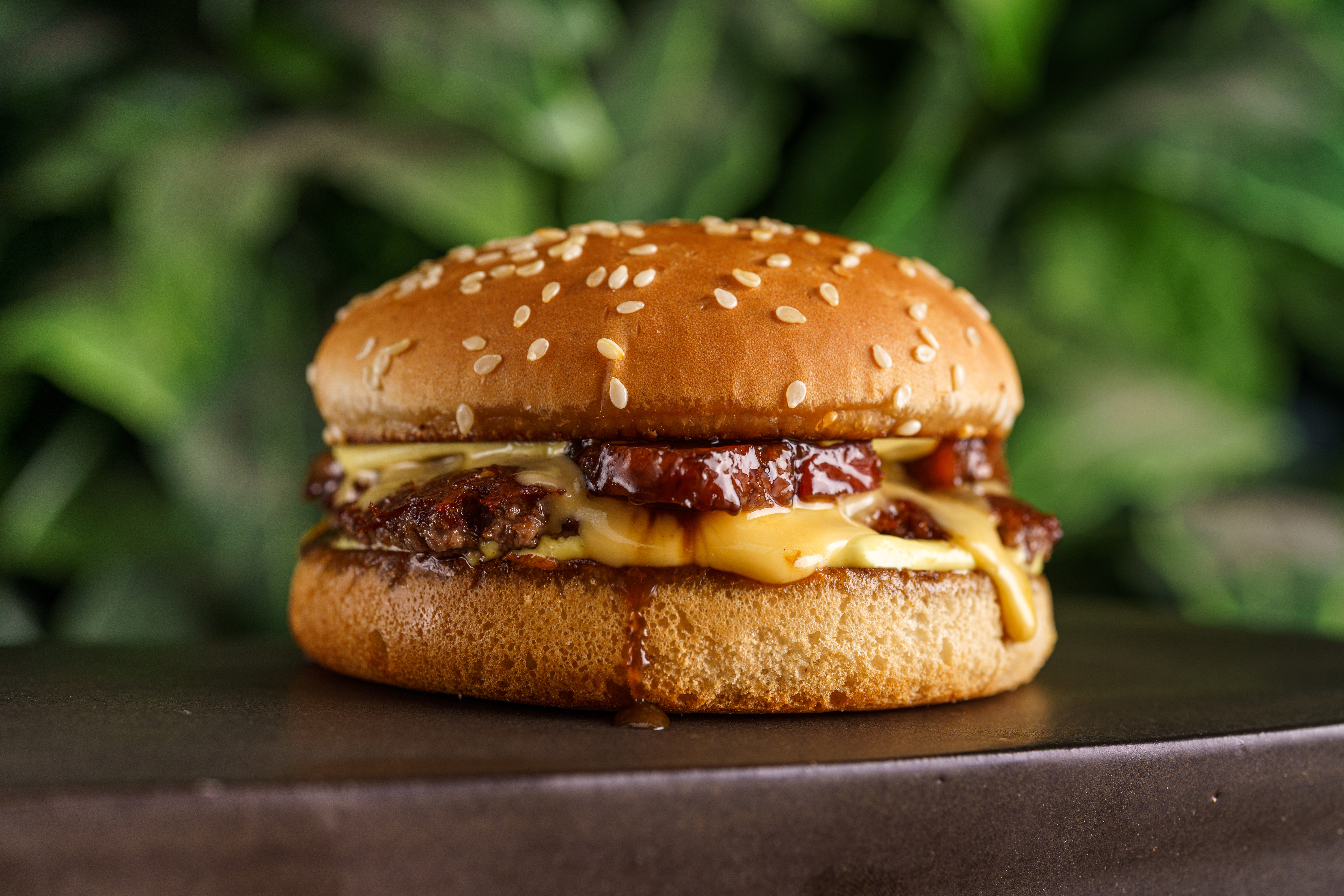 Cheese bacon servido no Jurassic Park Burger Restaurant composto de pão com gergelim branco, queijo e carne