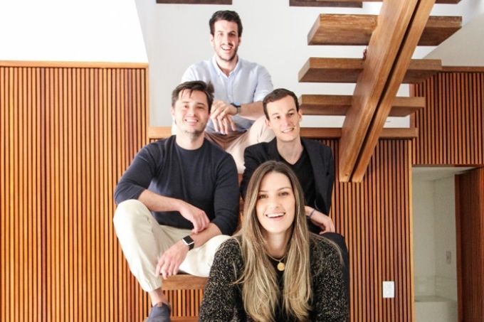 Diego, Guilherme, Taiana e André (em sentido horário) sentados em escada da imobiliária em que trabalham