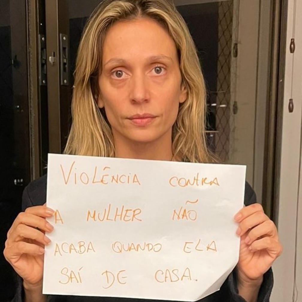 A imagem mostra Luisa Mell segurando um cartaz com os dizeres: "Violência contra a mulher não acaba quando ela sai de casa"