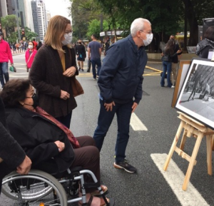 paulista-exposição Pessoas olhando retratos, que são parte da exposição Arte Na Rua, que acontece na Avenida Paulista