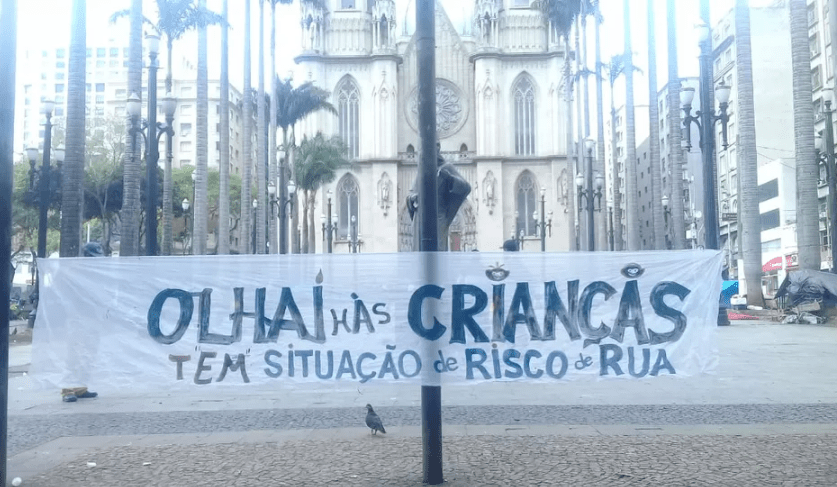 Em frente a Catedral da Sé, uma placa com o escrito: "Olhai as crianças em risco de situação de rua"