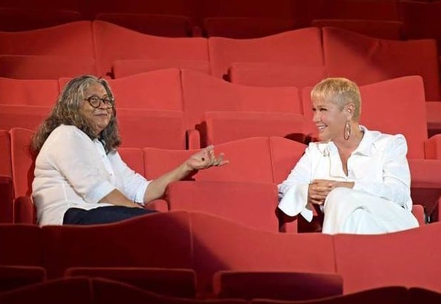 Xuxa e Marlene em um auditório conversando