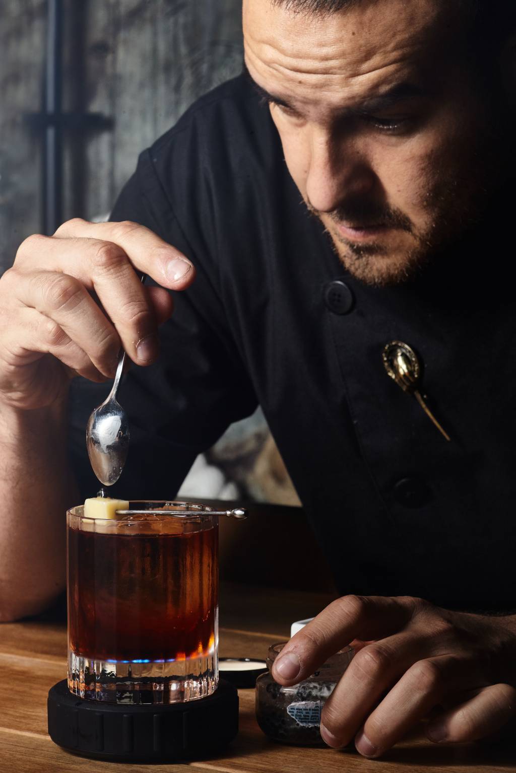 O bartender Aaron Diaz finalizando um drinque a sua frente.