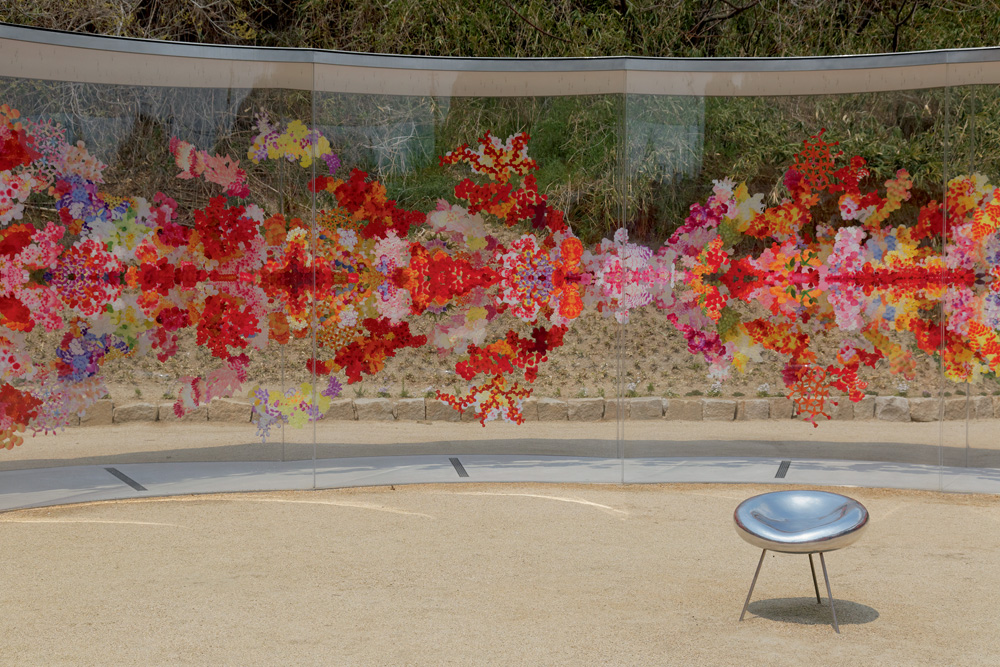 A imagem mostra um mural de vidro repleto de flores.