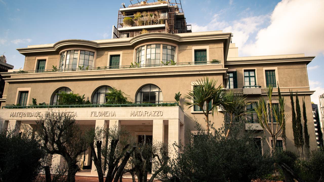 Fachada de hotel no Cidade Matarazzo com oliveiras na porta.