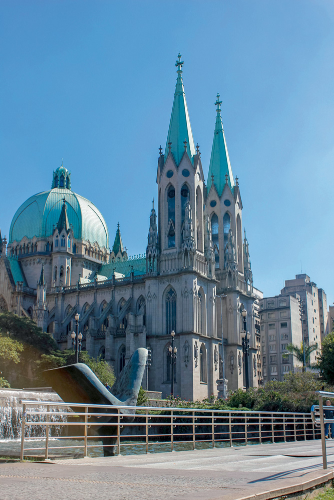 Foto de baixo para cima mostra a Catedral da Sé, em um dia de céu azul