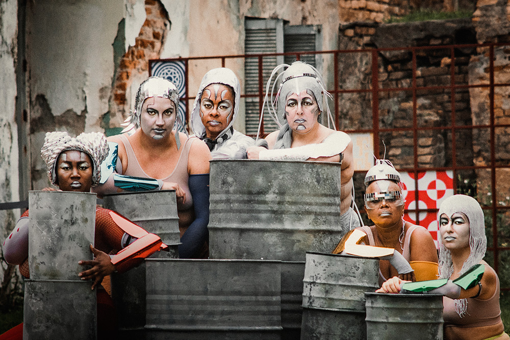 Na foto, seis atrizes da peça "As Mulheres de Cabelos Prateados" posam no set. Elas usam trajes prateados.