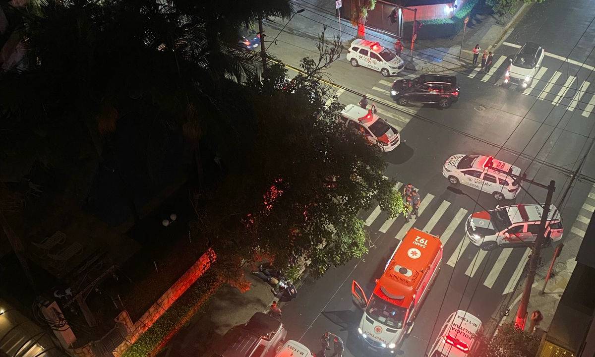 Imagem mostra rua com ambulância e viaturas de polícia