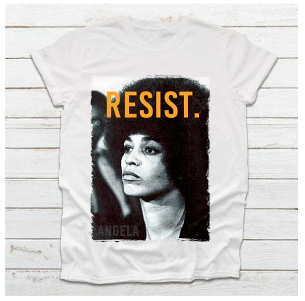 angela davis.png Uma foto de uma camiseta branca que tem no centro um retrato retangular de Angela Davis com a palavra