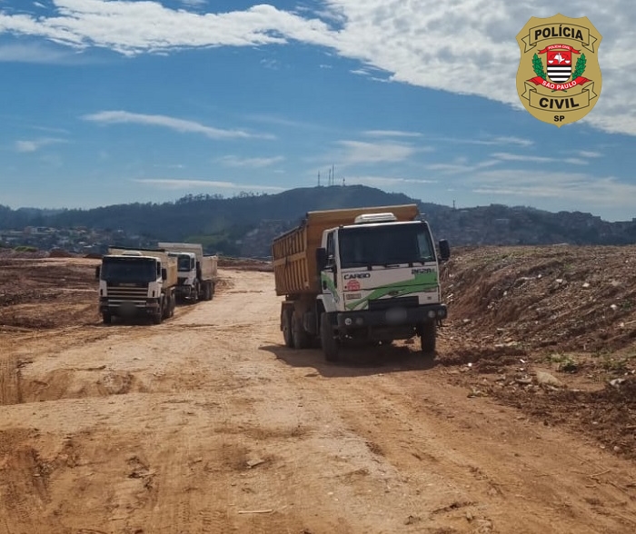 Imagem mostra dois caminhões parados em meio a área completamente desmatada