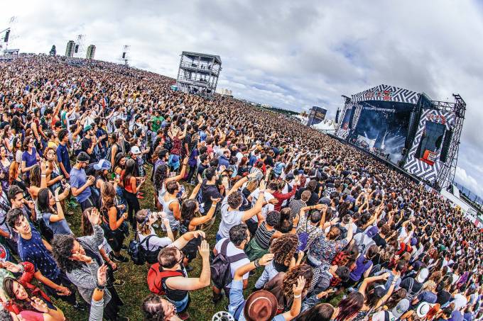 Imagem mostra multidão de pessoas aglomeradas em frente a um palco.