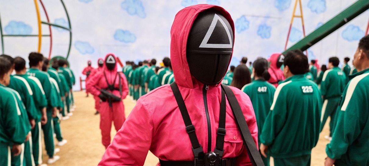 A imagem mostra figuras com roupas vermelhas e faces tampadas segurando armas