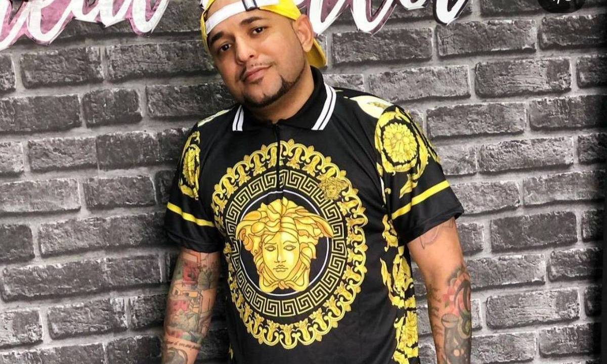 imagem mostra MC Boco do Borel de camiseta preta e amarela, e boné amarelo com a aba virada para trás