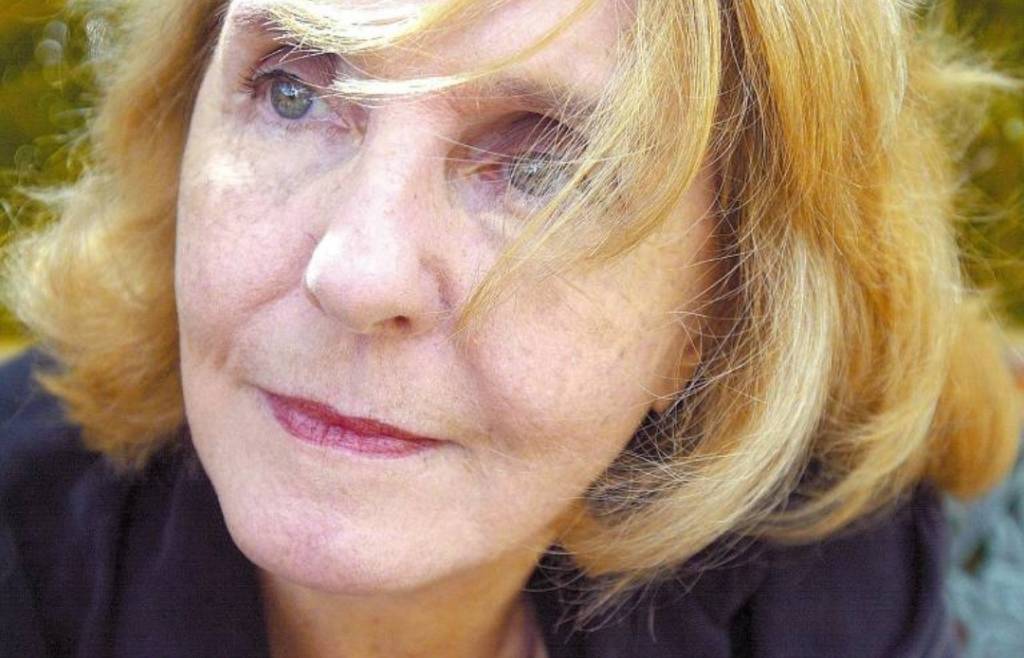 Retrato de Lya Luft, uma mulher idosa, de pele branca, cabelos loiros e olhos verdes.