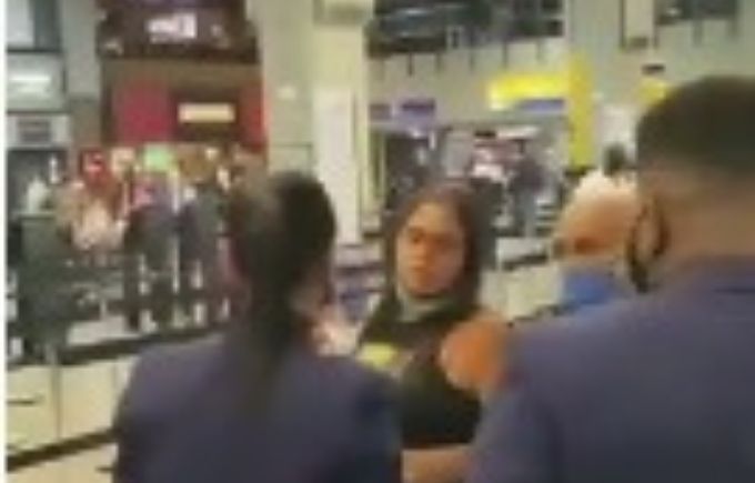 Foto mostra funcionários da Latam conversando com passageira que invadiu check-in
