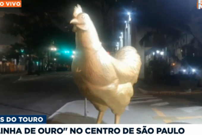 A imagem mostra uma estátua de galinha em tons dourados no centro de São Paulo