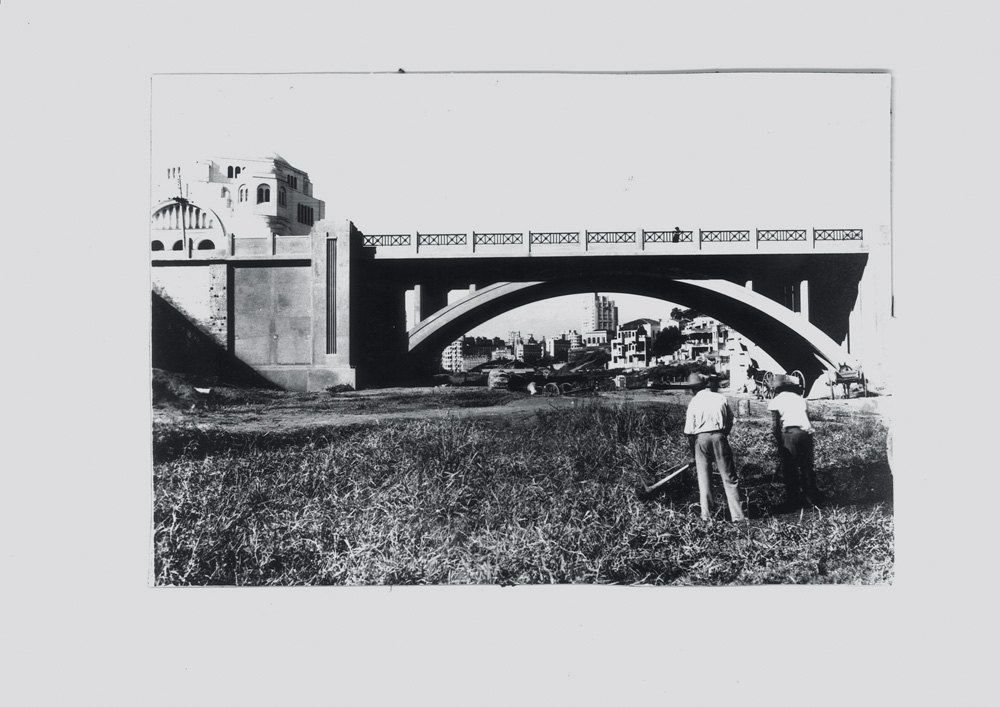 Uma foto em preto e branco bem antiga mostra o Viaduto Martinho Prado sobre o futuro leito da Avenida Nove de Julho