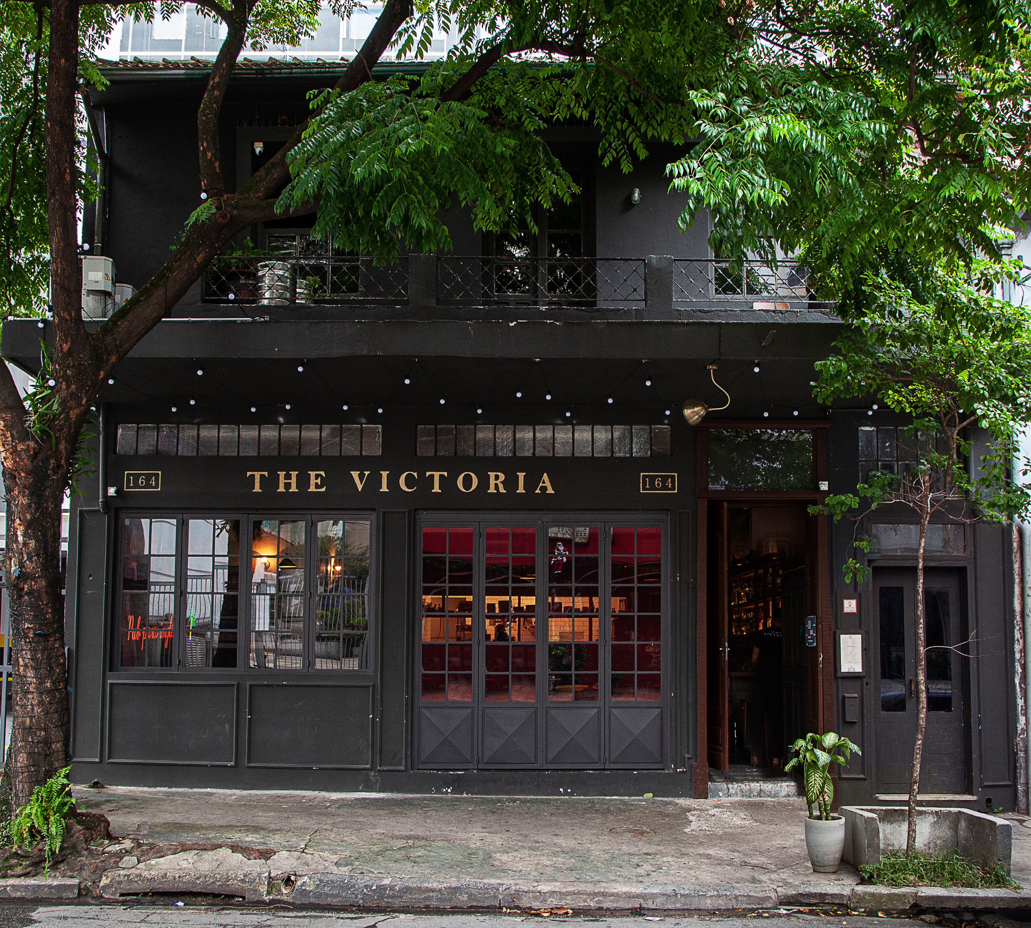 A fachada de vidro e paredes pretas do pub The Victoria.