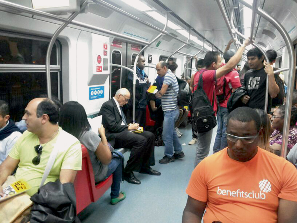 Suplicy aparece sentado ao fundo, no metrô de São Paulo. Ele veste terno.