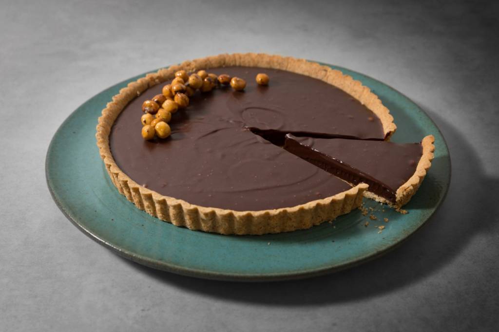 Confeitaria Marilia Zylbersztajn Torta com cobertura de chocolate e avelãs no topo