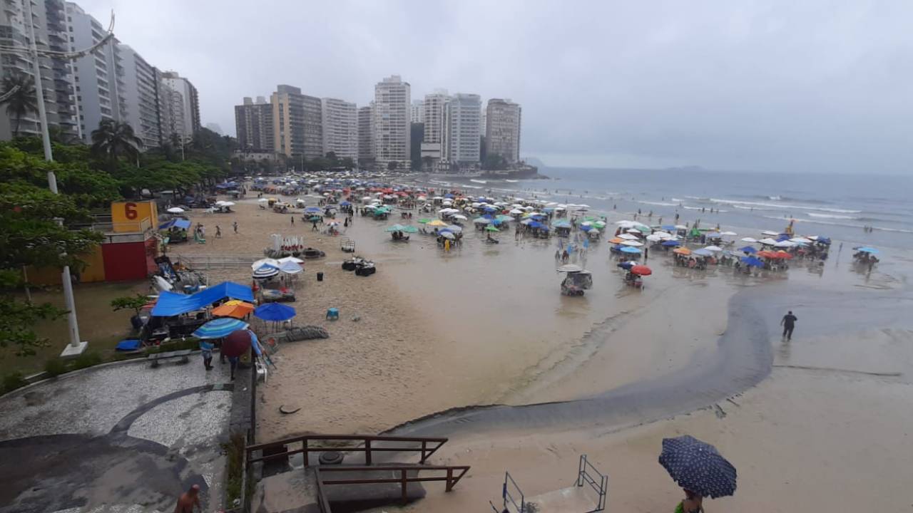 Banhistas em praia com chuva