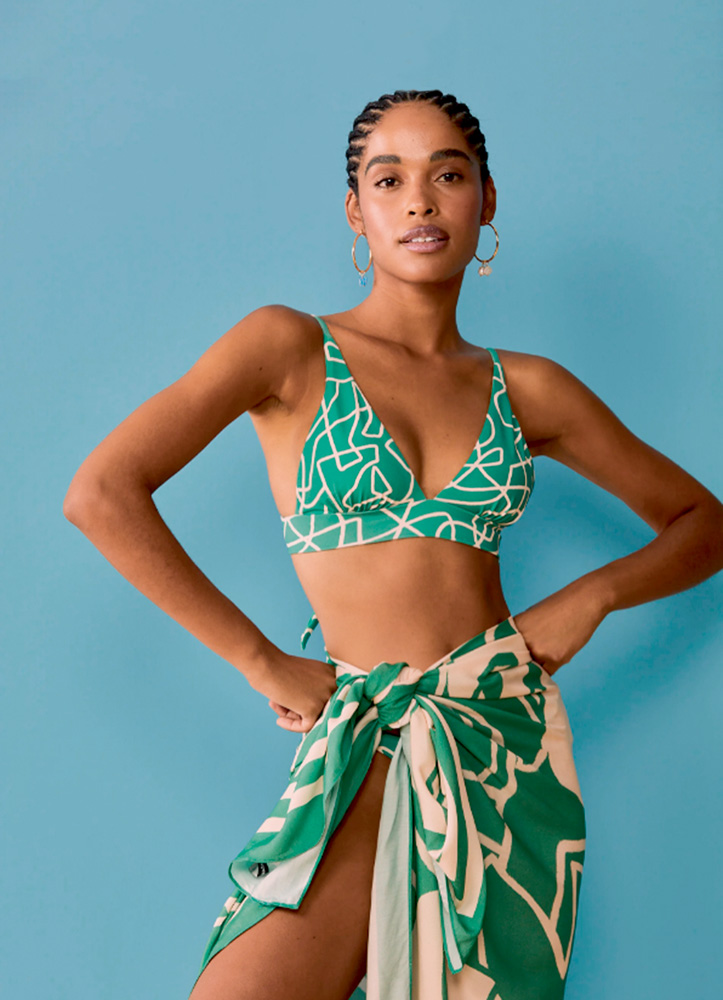 biquini.png Mulher negra está de biquíni verde, mãos na cintura e canga amarrada na cintura