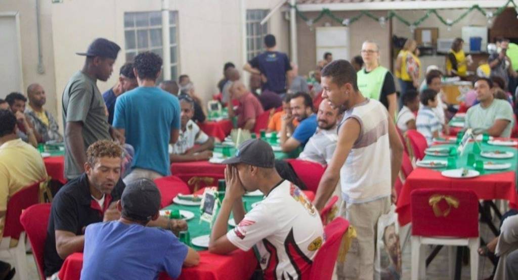 ABCP Pessoas em situação de rua celebram a ceia de Natal em mesas postas na sede da ABCP.