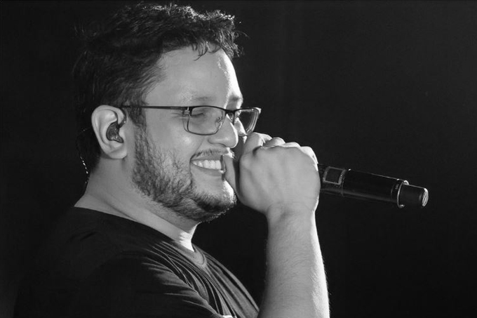 Foto preto e branco do cantor Maurílio cantando.