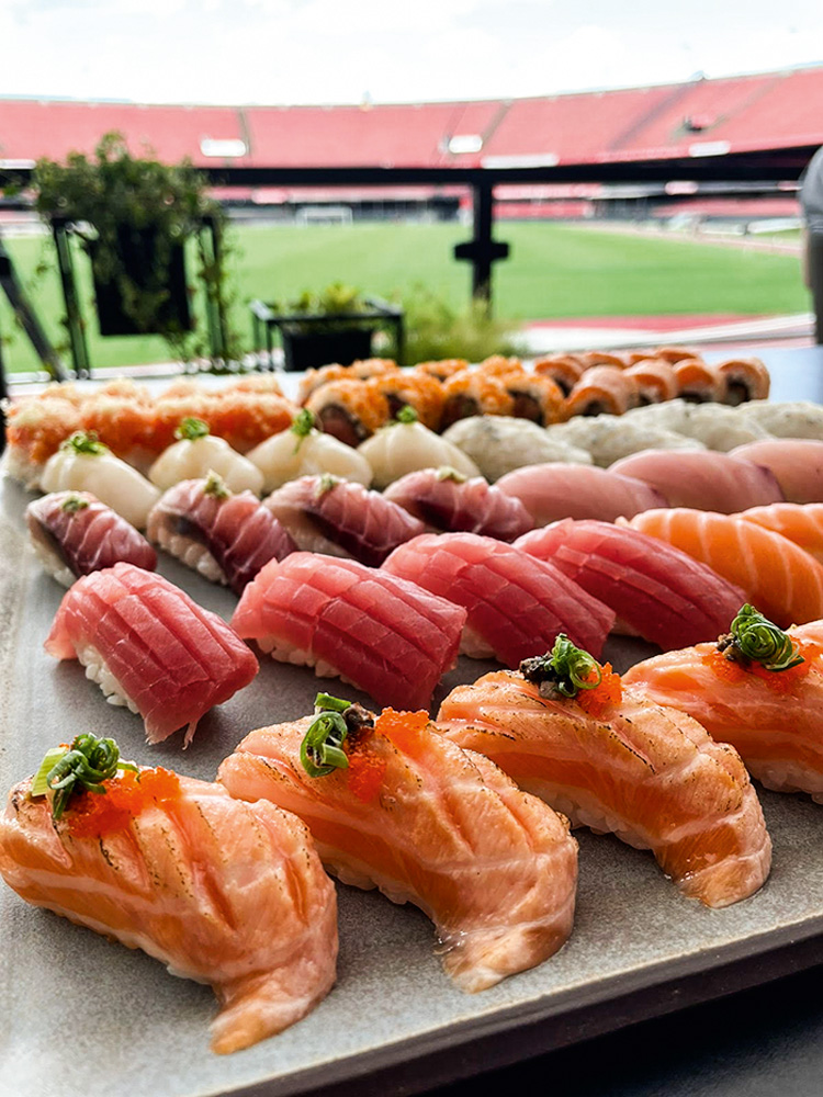 Seleção de sushis em bandeja com estádio ao fundo