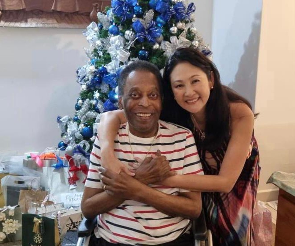 imagem mostra Pelé, de camiseta listrada, abraçado à esposa
