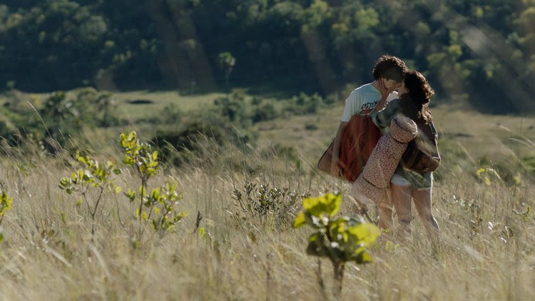 Cena do filme Eduardo e Mônica: casal se beijando em meio uma paisagem natural