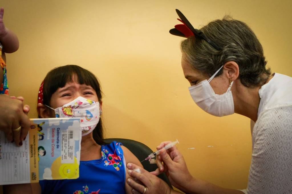 Criança toma vacina contra a Covid-19