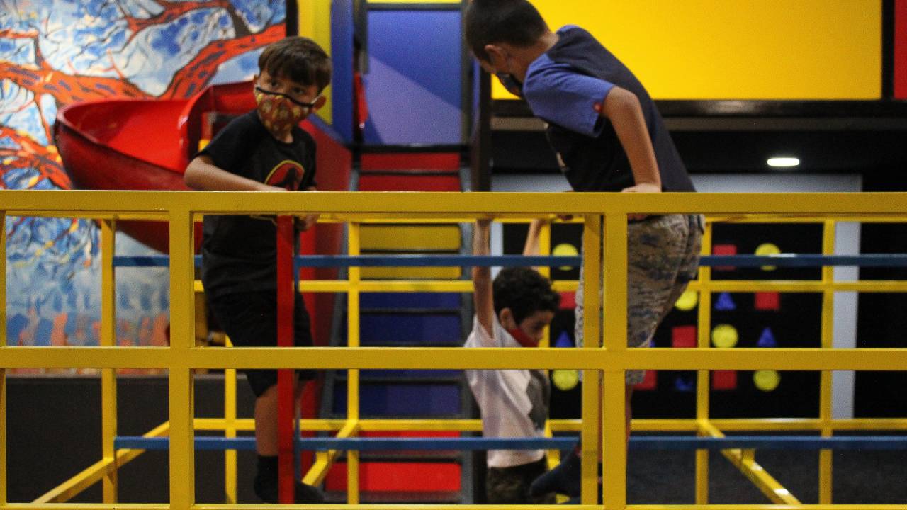 Crianças de máscara brincam nos playgrounds do Museu da Imaginação.