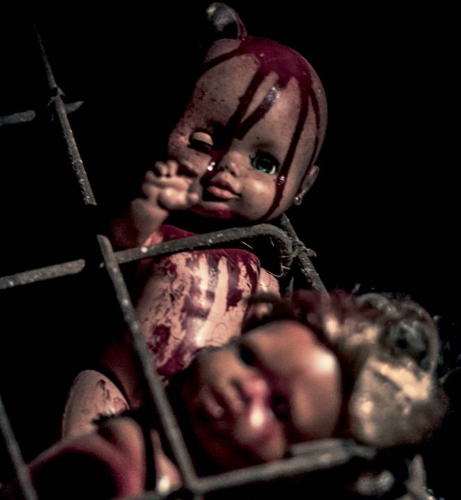 A foto mostra uma boneca com simulação de sangue no rosto