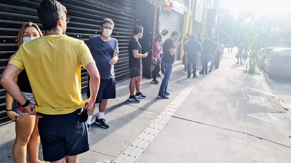 Pessoas esperam na rua em fila para fazer testes de Covid-19.