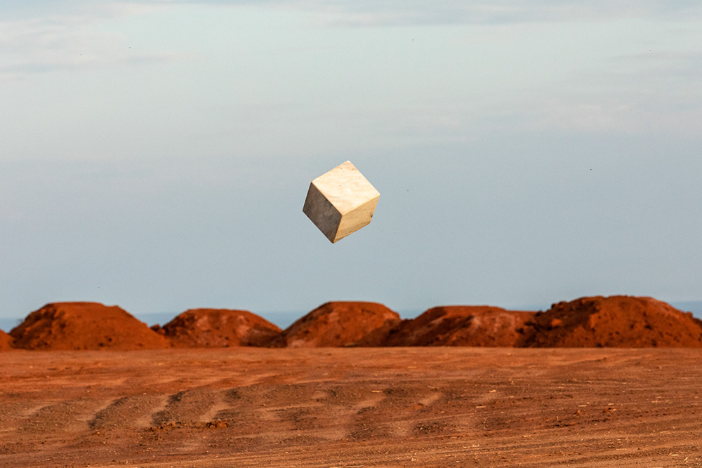 Obra de João Angelini é uma foto que mostra um quadrado flutuando no céu, acima de um deserto.