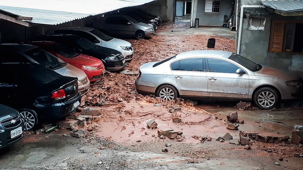 Foto mostra um estacionamento atingido pela lama de um deslizamento.