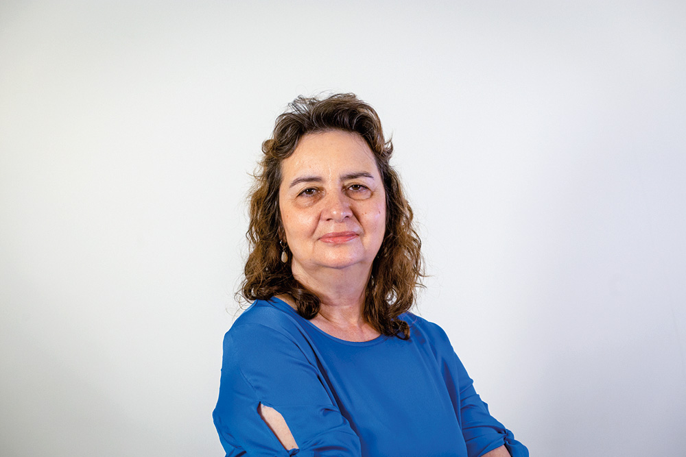 lucia-helena.jpg Imagem mostra mulher de roupa azul sobre fundo branco