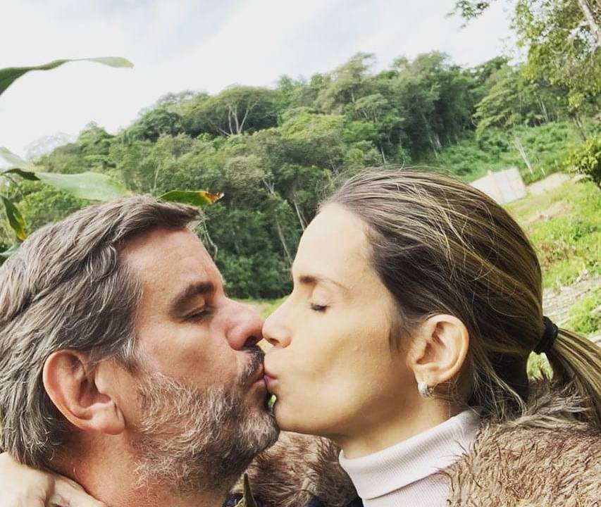 Imagem mostra Bruno e Karina se beijando em selfie, com ambiente arborizado no entorno