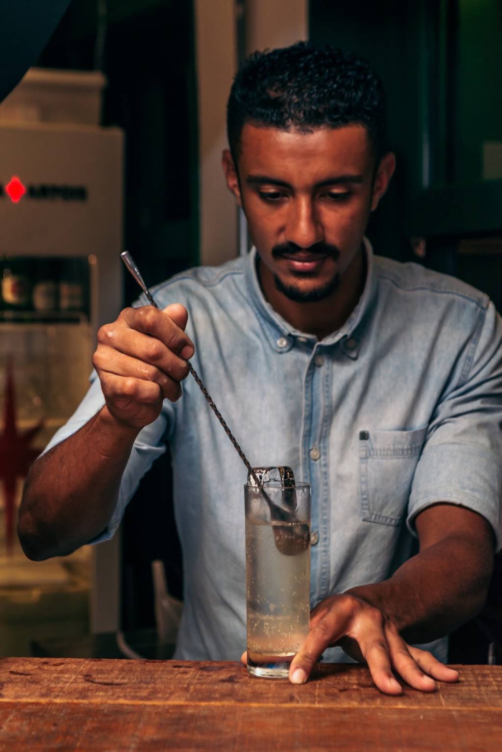 Liz Cocktails & Co Homem mexe em copo com colher
