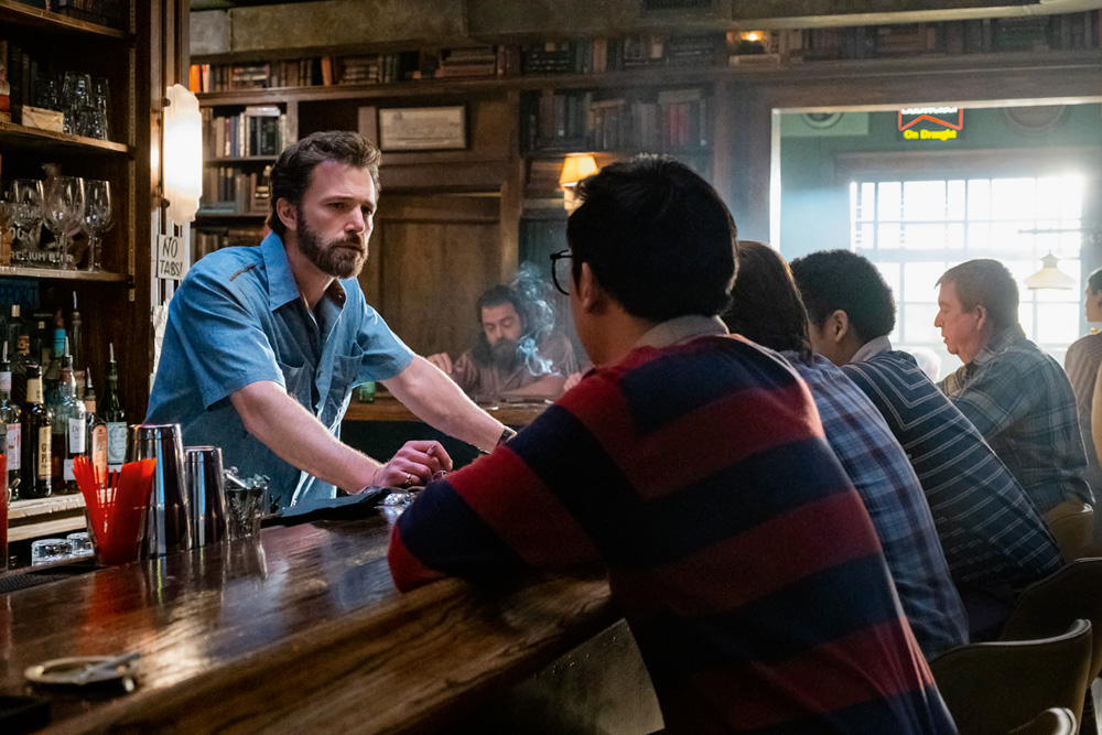 Imagem mostra diversos homens em uma bancada de um bar.