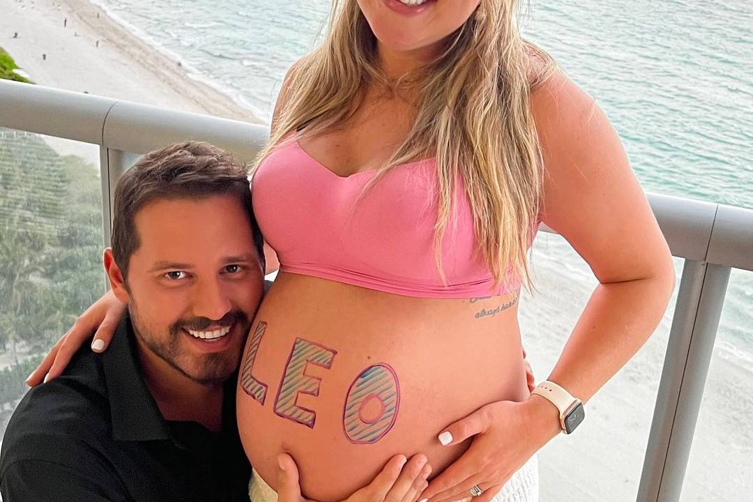Imagem Dony com a esposa. Ela está grávida e com o nome do bebê escrito na barriga: 'Leo'