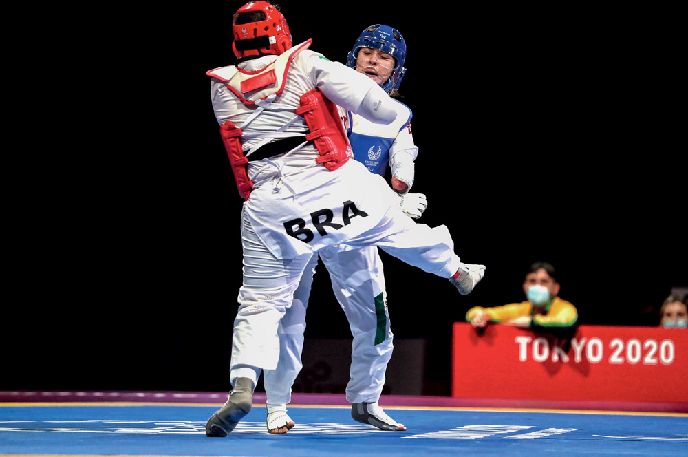 Imagem mostra duas pessoas lutando tae kwon do.