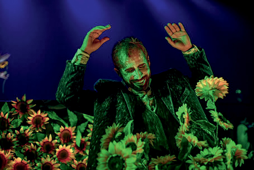 Um ator fantasiado de Van Gogh contracena em uma plantação de girassóis