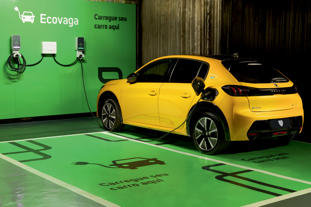 Imagem mostra carro amarelo sendo abastecido em espaço verde com o logo escrito 