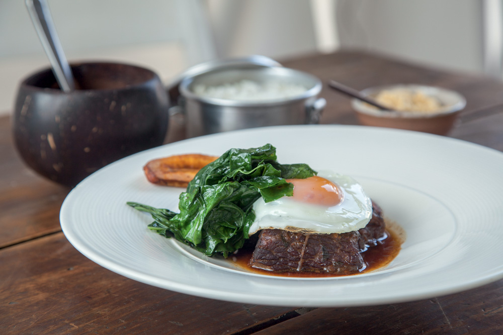 Picadinho de carne de panela_04.jpg Prato branco com carne bovina, ovo e couve por cima.