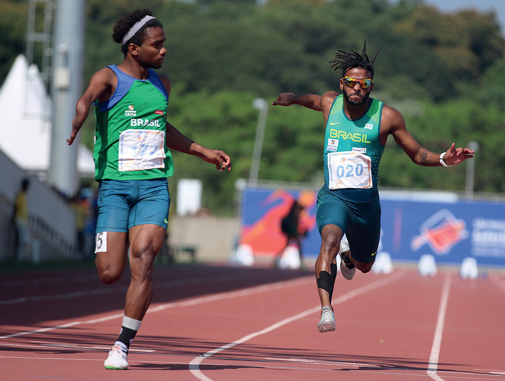 Imagem mostra dois homens correndo em pista.