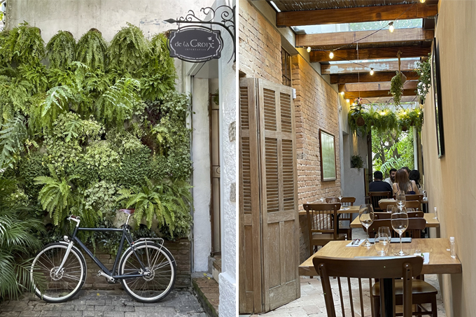 Duas imagens divididas por linha fina branca. À esquerda fachada da la Croix com bicicleta em frente à parede de plantas. À direita, salão do Bar à Vins.