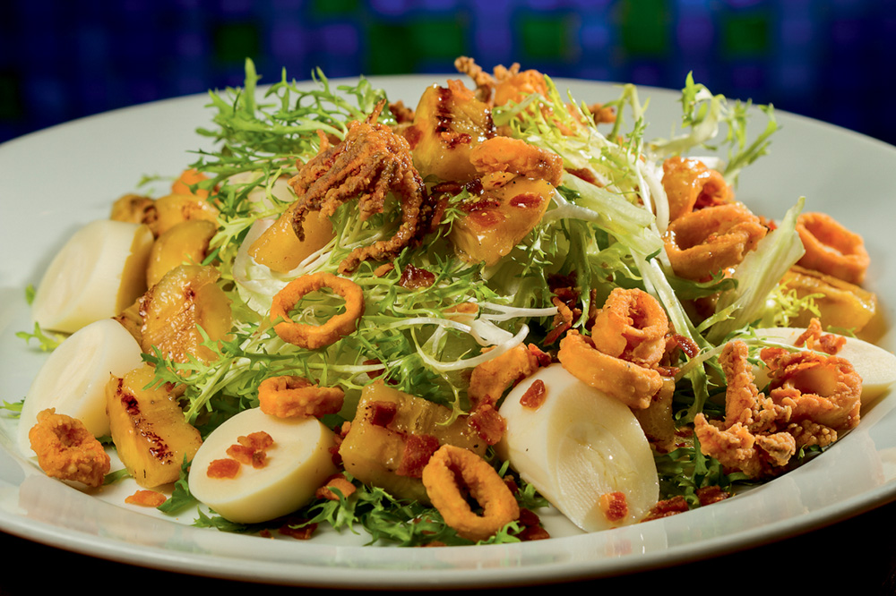 Salada com palmito, folhas verdes e mais é servida em louça de cor branca